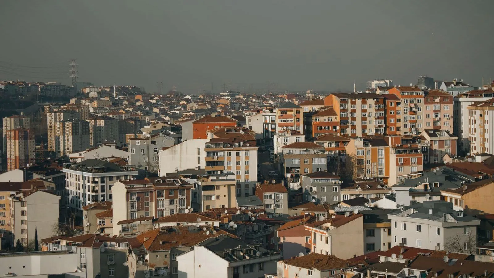 Dense city apartment blocks under a heavy grey sky.