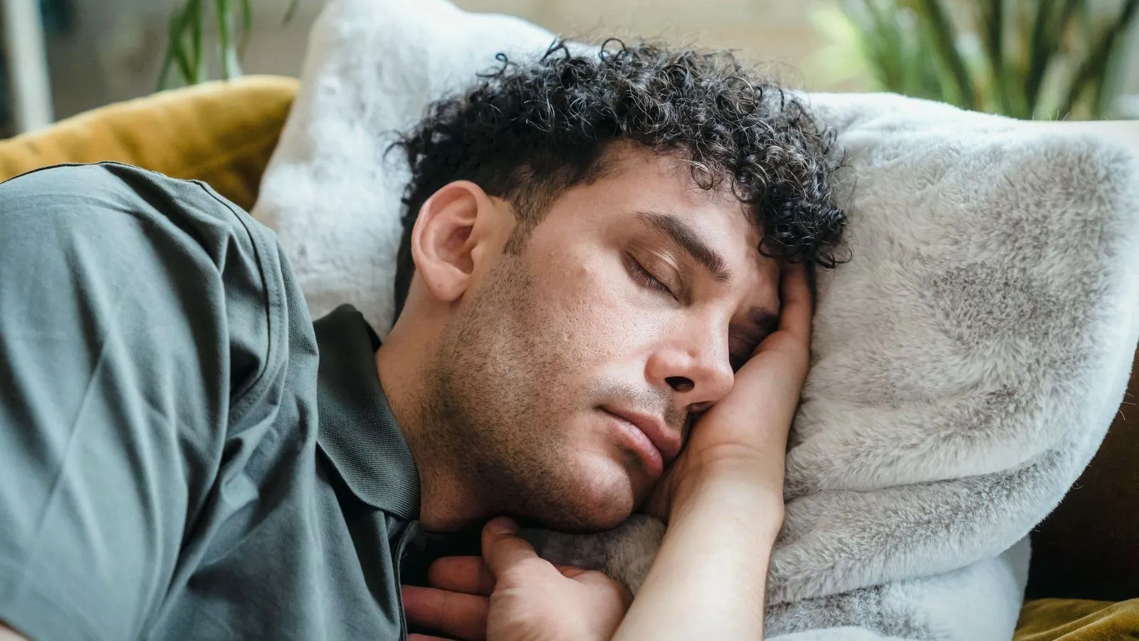 A man asleep with his head resting on a soft pillow.