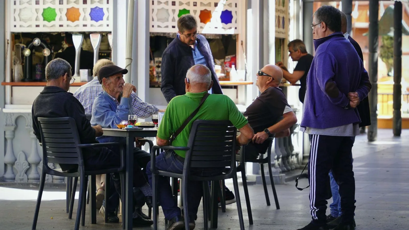 A busy cafe with people sitting and standing at tables, talking