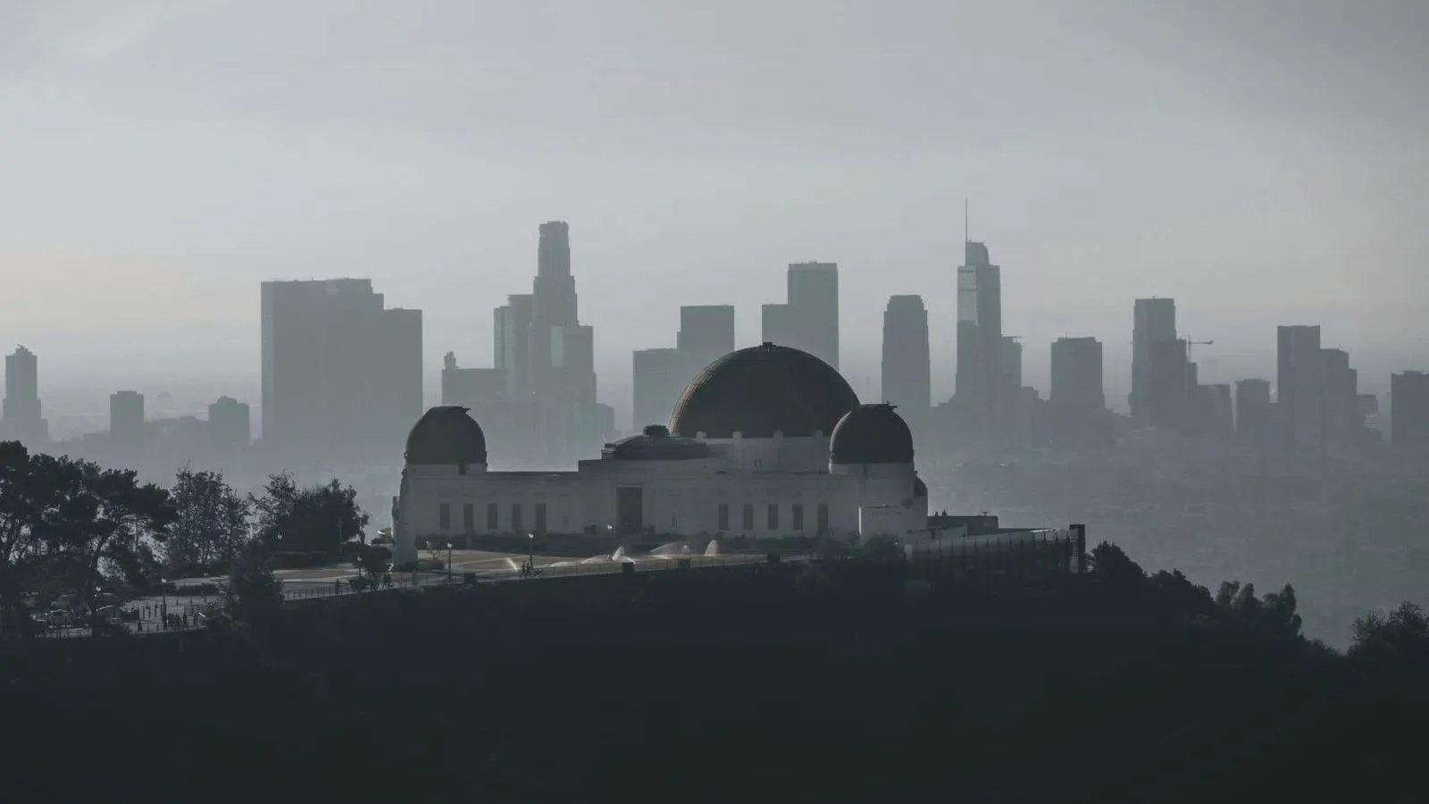 A city skyline and hilltop observatory almost lost in thick gray haze