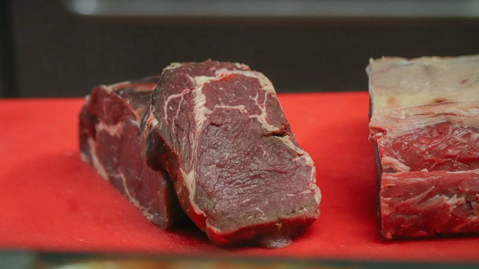 Cuts of raw red beef on a butcher counter