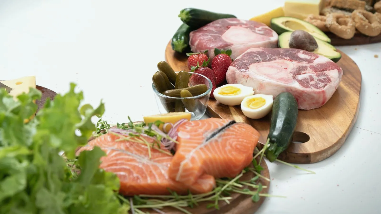 A board of salmon, meat, boiled eggs, avocado, cheese and salad leaves