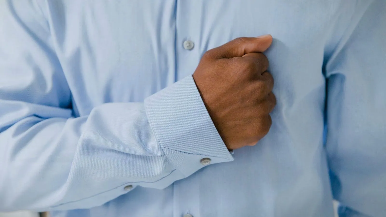 A person pressing a fist against the center of their chest