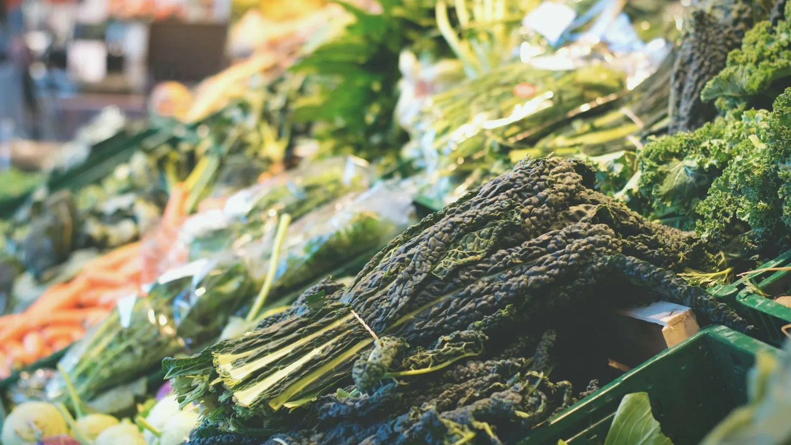 Bunches of kale and dark leafy greens on a market stall