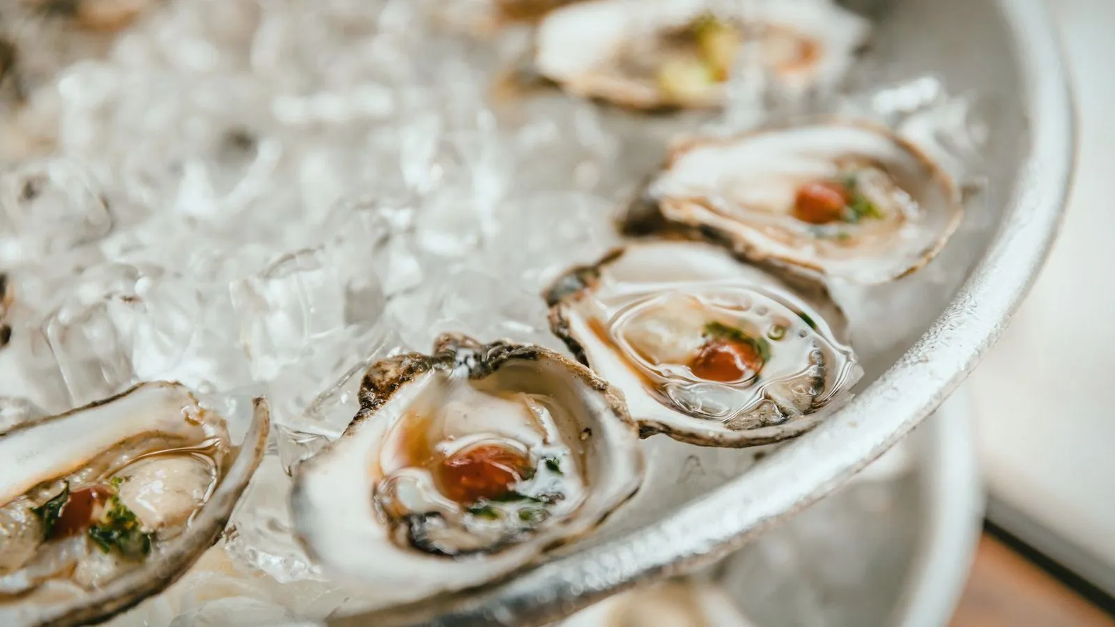 Fresh oysters on the half shell arranged on a platter of crushed ice